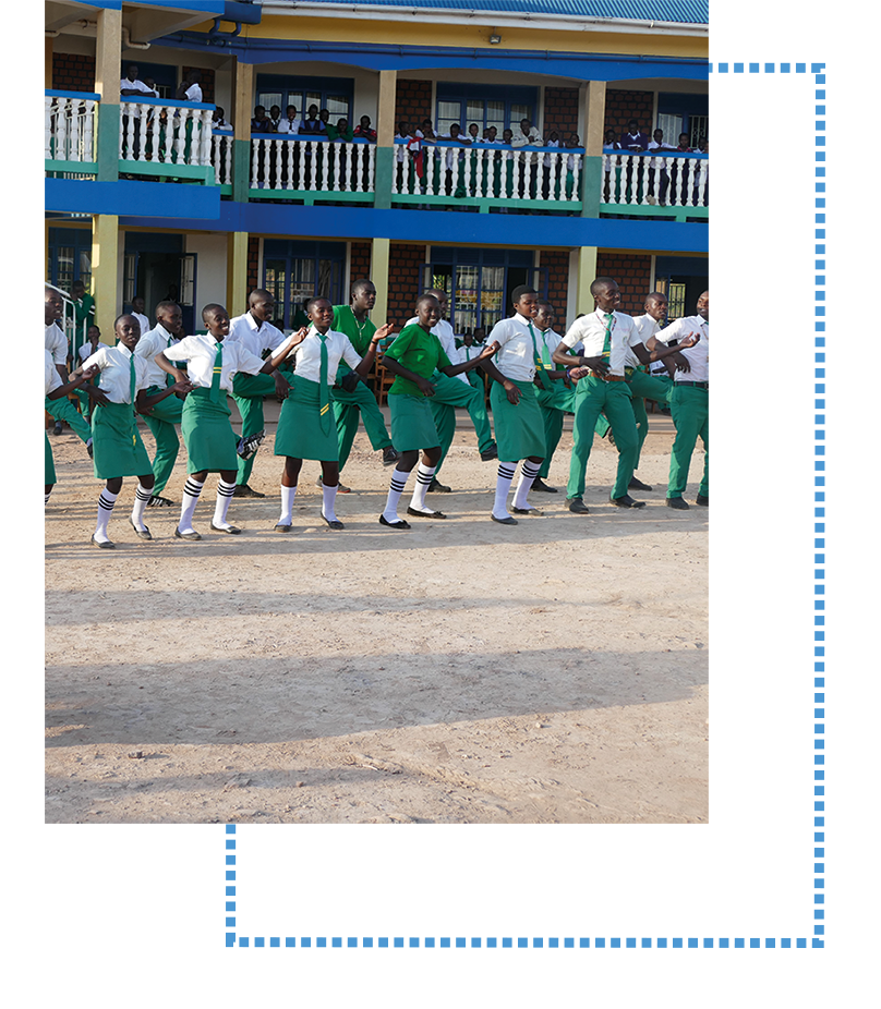 Die Schüler tanzen vor dem Schulgebäude.